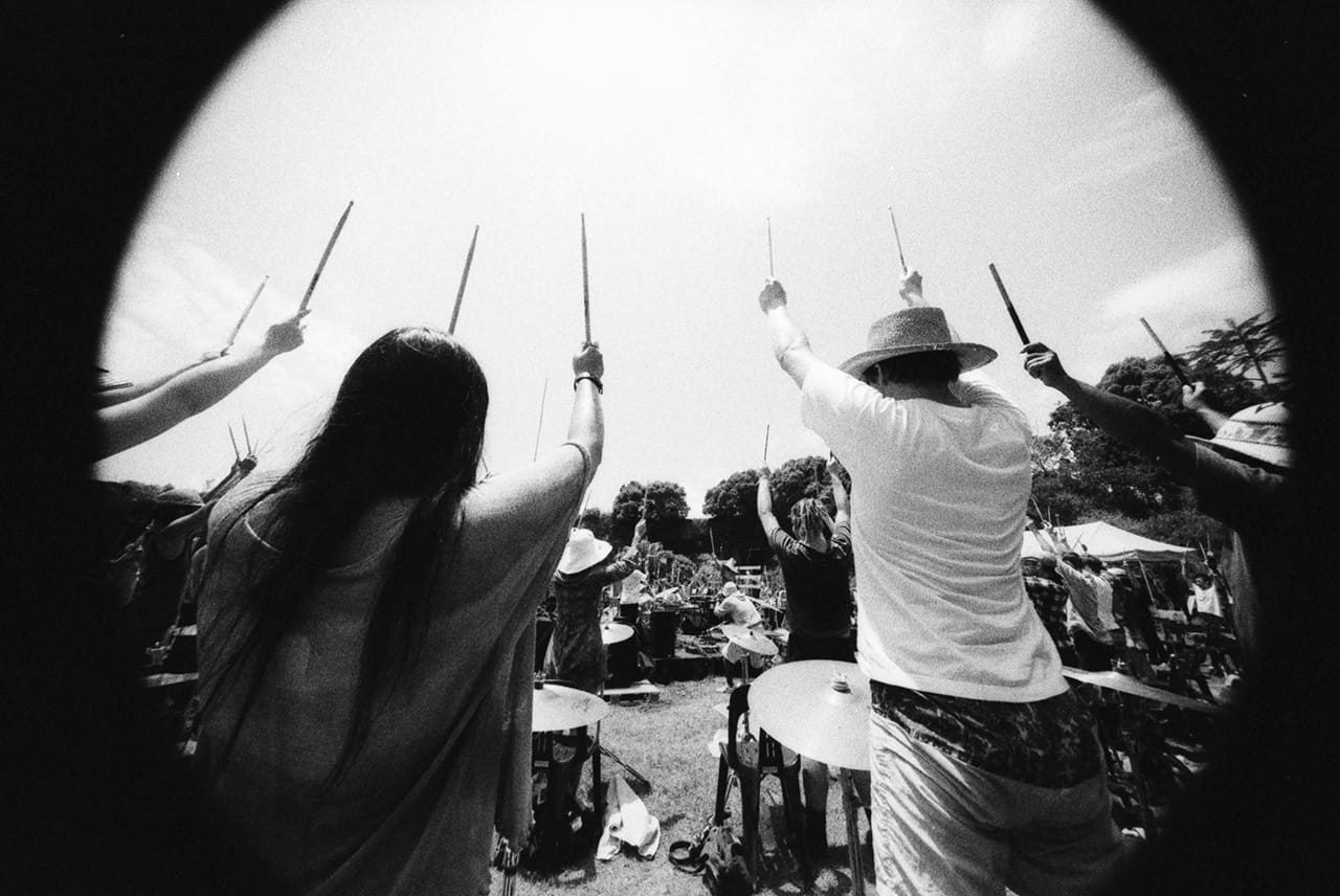 The players await the official Aerial Photography from an approaching helicopter - Boredoms - Boadrum111 - Byron Bay November 2011